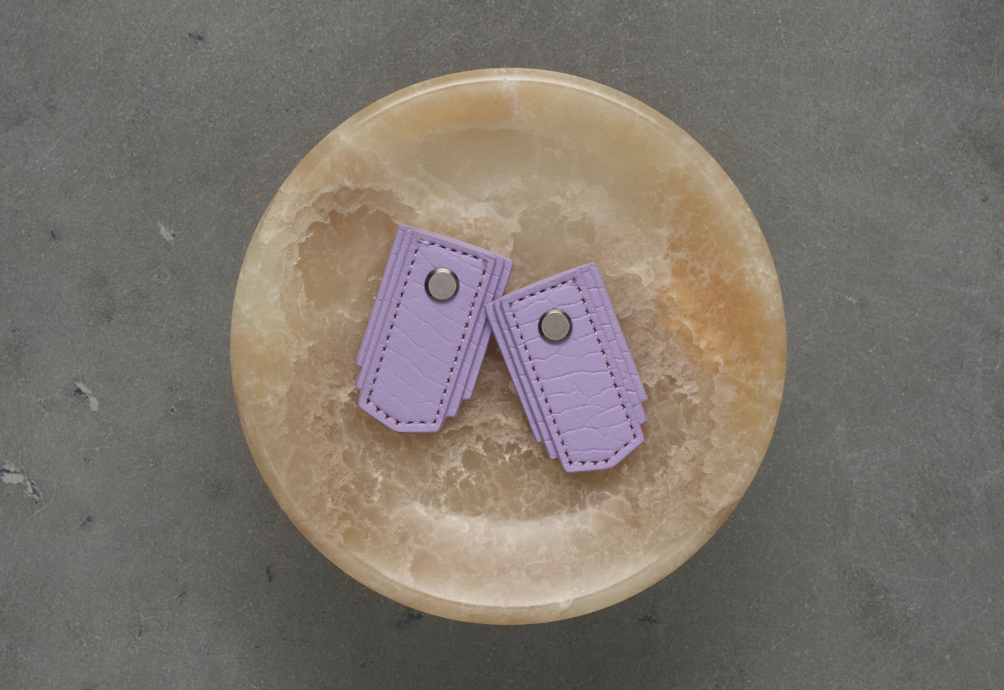 Lavender leather pull handle by Sagitine, featuring a sleek design perfect for cabinets or drawers.