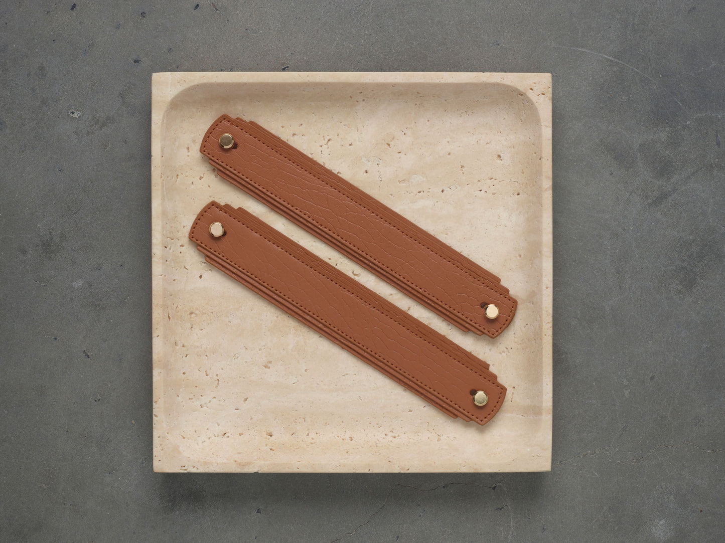 Tan leather handle by Sagitine, featuring a smooth finish and a sturdy design.